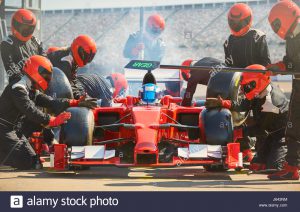 pit-crew-working-on-formula-one-race-car-in-pit-lane-J643NM